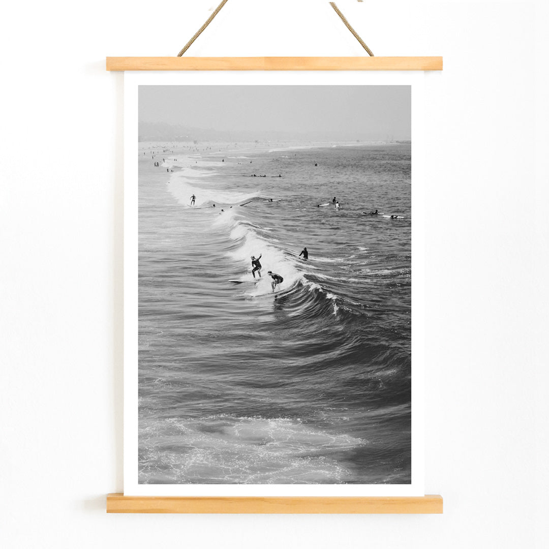 Black and white surfers riding waves at Venice Beach coastal wall art poster ideal for home decor, with wooden magnetic frame on white background