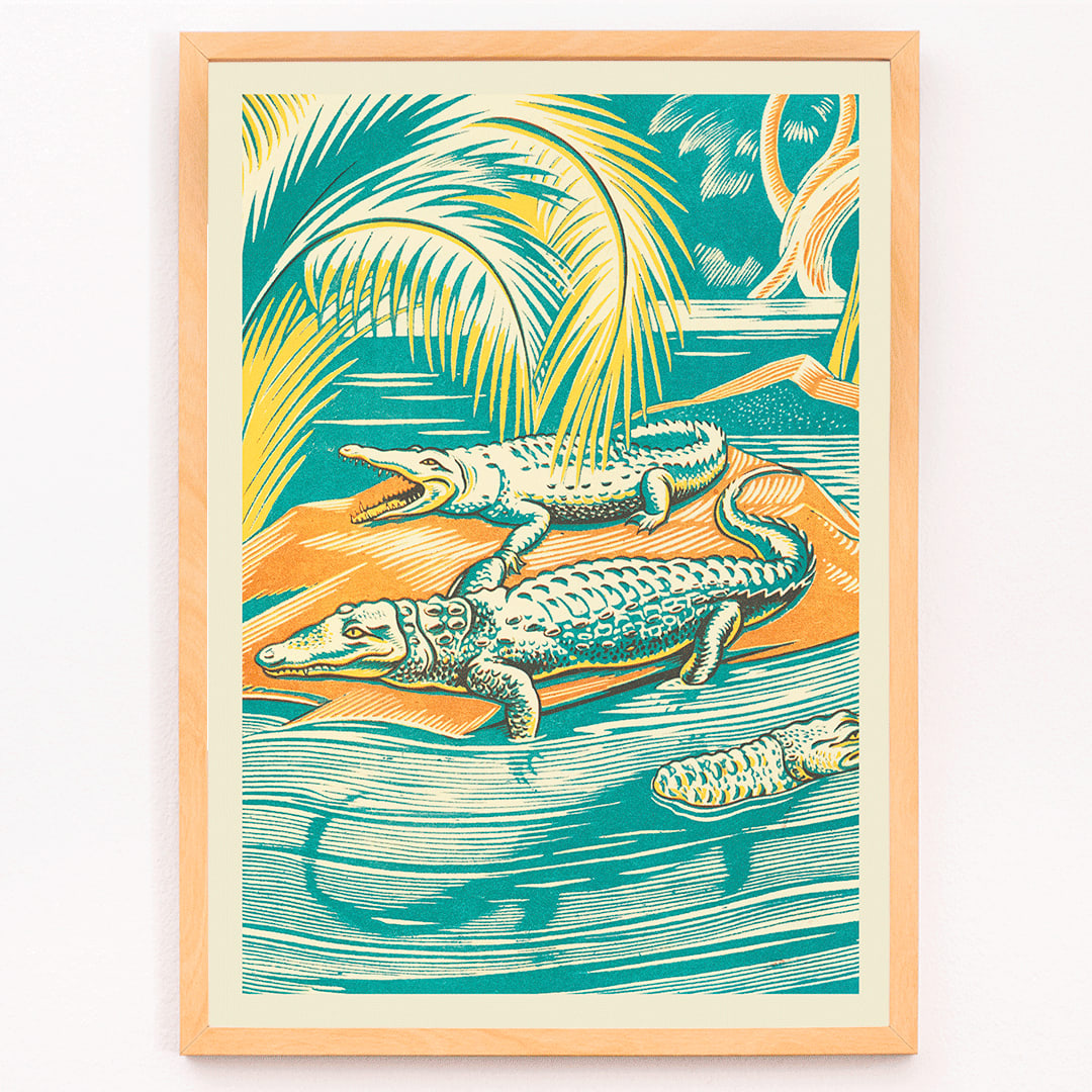 A Jungle Picnic Pl.03 Crocodile by Clifford Webb vibrant jungle artwork and poster showing crocodiles resting by a river under palm trees, framed and displayed in modern living room decor