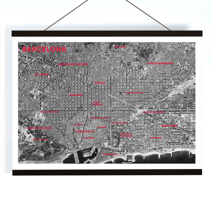 Moryarty Barcelona satellite city map poster in bold black and white aerial style showing city grid districts landmarks monuments and coastline, with wooden magnetic frame on white background