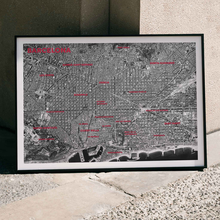 Moryarty Barcelona satellite city map poster in bold black and white aerial style showing city grid districts landmarks monuments and coastline, framed and displayed in home decor