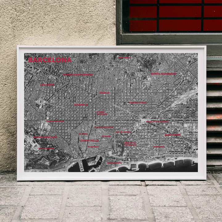 Moryarty Barcelona satellite city map poster in bold black and white aerial style showing city grid districts landmarks monuments and coastline, framed and displayed in modern living room decor