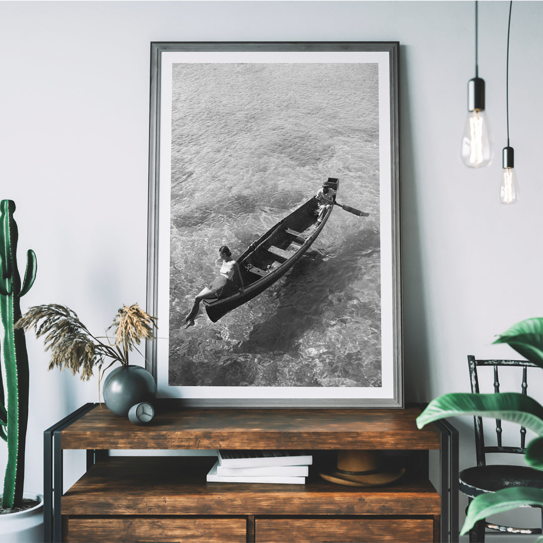 Fashion model on boat edge with man rowing in clear water Montego Bay Jamaica by Toni Frissell artwork poster, framed and displayed in home decor