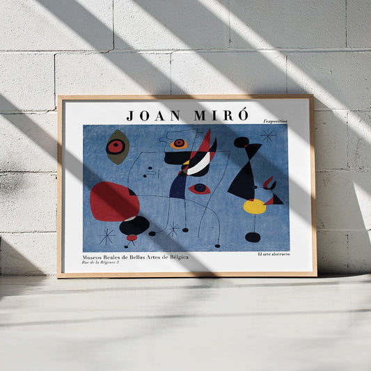 Exhibition poster of abstract artwork Woman and Bird at Night by Joan Miro with colorful shapes on a blue background, framed and displayed in home decor