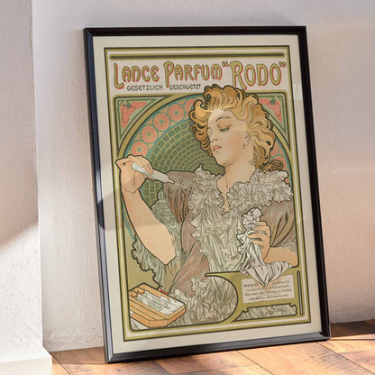 Alphonse Mucha Lance parfum Rodo poster Art Nouveau woman with flowing hair floral border soft green gold tones, framed and displayed in modern living room decor