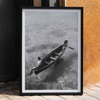 Fashion model on boat edge with man rowing in clear water Montego Bay Jamaica by Toni Frissell artwork poster, framed and displayed in home decor