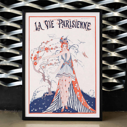 Elegant Art Deco poster of a woman in a floral dress standing by a blossoming tree La Vie Parisienne by Umberto Brunelleschi, framed and displayed in modern living room decor