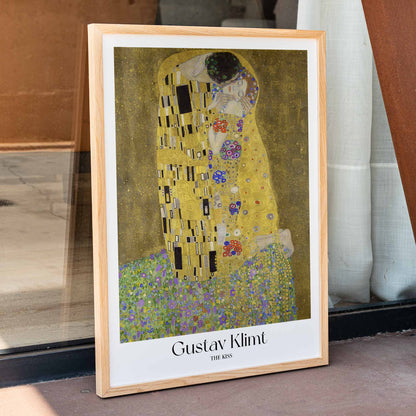 The Kiss by Gustav Klimt featuring two lovers embracing in a richly decorated golden background with floral patterns romantic couple artwork poster, framed and displayed in home decor