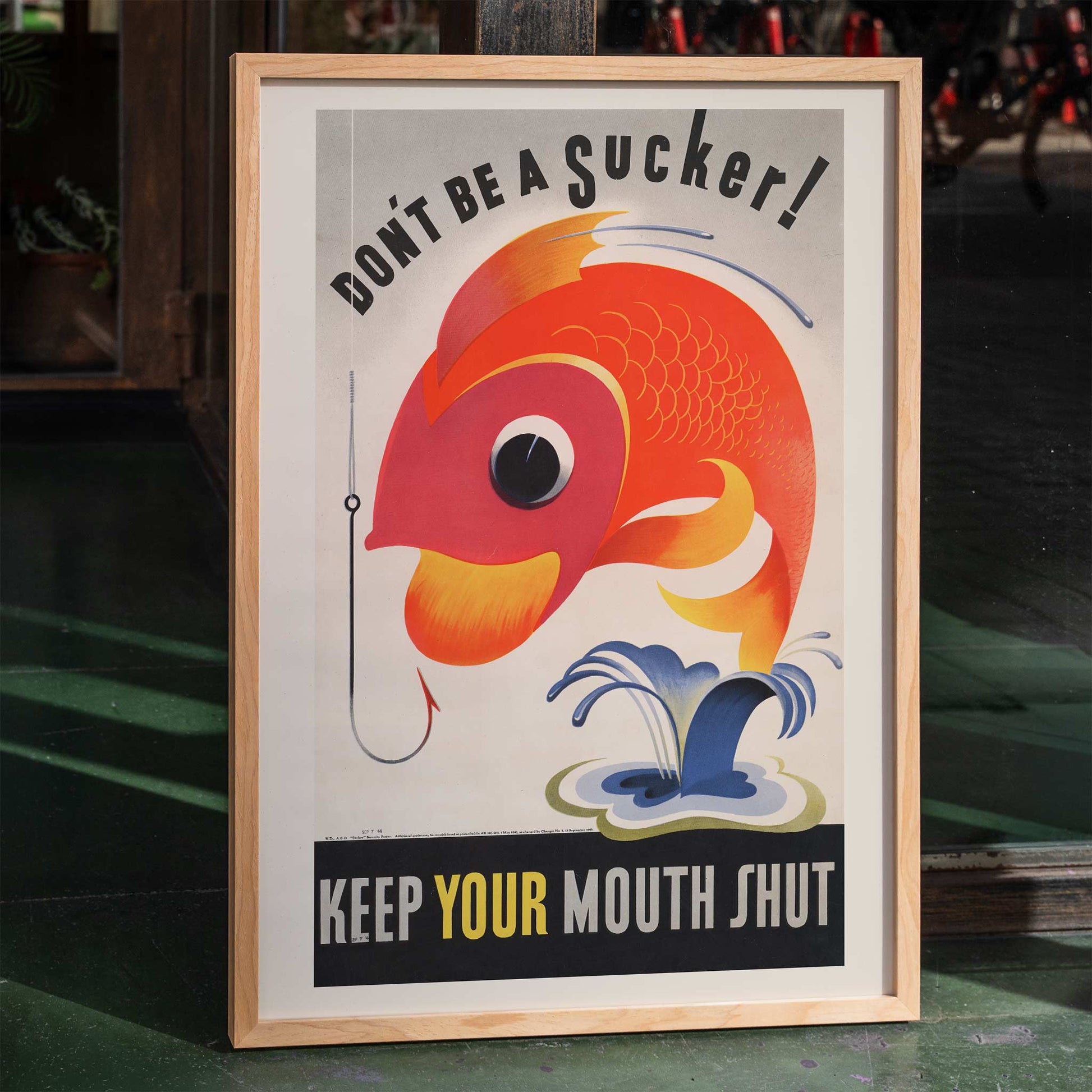 Poster Dont be a sucker Keep your mouth shut by unknown artist featuring a colorful abstract fish near a hook with a bold message, framed and displayed in home decor