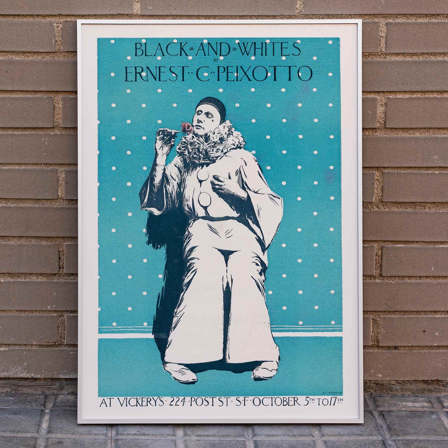 Ernest Peixotto black and white artwork poster of a clown with a polka dot background holding a flower, framed and displayed in home decor