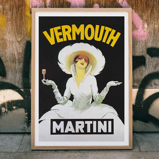 Vermouth Martini by Marcello Dudovich vintage poster art featuring an elegant woman in white holding a glass against a black background, framed and displayed in home decor