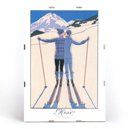 Two skiers kissing in snowy mountain landscape L Hiver by George Barbier vintage poster artwork, framed and displayed in modern living room decor