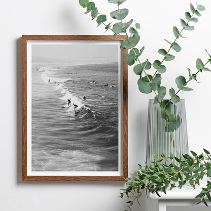 Black and white surfers riding waves at Venice Beach coastal wall art poster ideal for home decor, framed and displayed in home decor