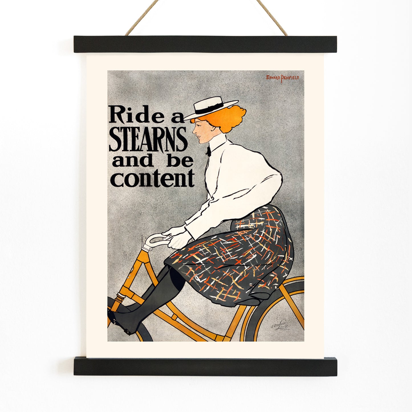 Vintage poster of a woman riding a bicycle with the text Ride a Stearns and be content by Edward Penfield artwork, with wooden magnetic frame on white background
